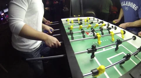 Guys playing Foosball Table soccer at a sports bar Stock Footage 45430802
