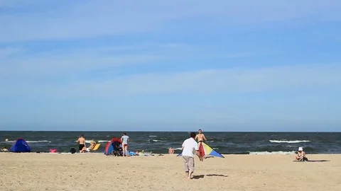Guys practicing with a kite on a beach Stock Footage 99119122