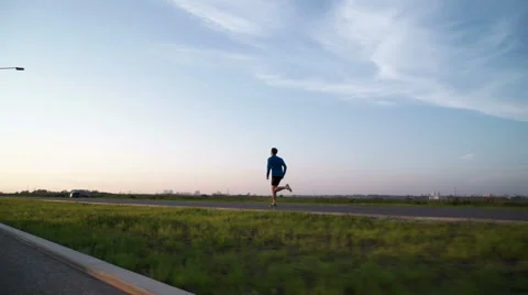 The guy's running at sunset on the sidewalk Stock Footage 64492519