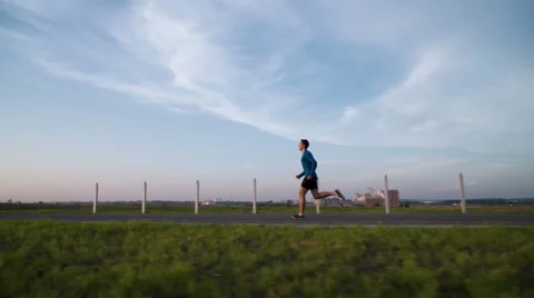 The guy's running at sunset on the sidewalk Stock Footage 64492998