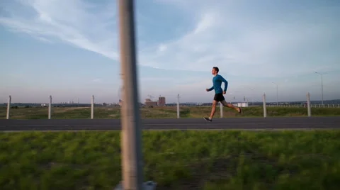 The guy's running at sunset on the sidewalk Видео 64493826