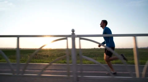 The guy's running at sunset on the sidewalk Stock Footage 64494283
