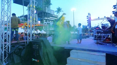 The guys on stage are taking a selfie with the colorful smoke and the dancing 動画素材 334119911