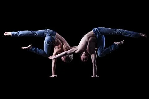 Guys stand on one hand next to each other, strong athletes. sexy people Stock Photos
