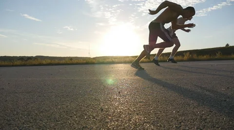 Guys standing at starting line at rural road at sunset. Slow motion. Stock Footage
