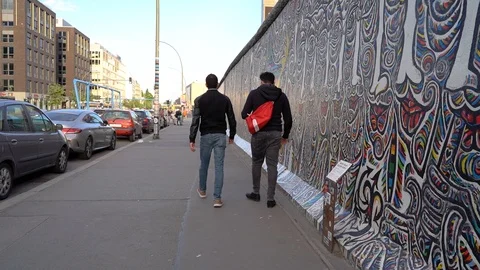 Guys visiting the Berlin Wall at sunset Video stock 108550121