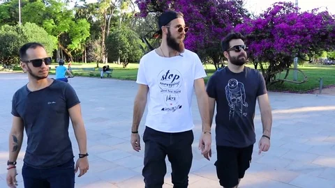 Guys Walking and Looking at The Side in Slow Motion on a Park in a Sunny Day Vídeo Stock 97027375