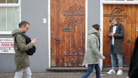 Guys watch the smartphone while people are walking Stock Footage 85288515