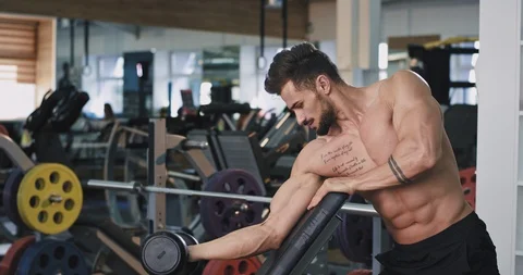 In a gym class concentrated fit man working on his biceps lifting up the Stock Footage 114760235