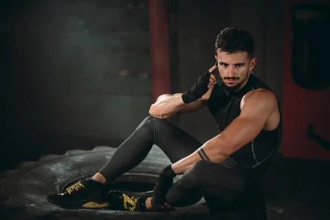 In the gym class good looking athletic guy speaking on his phone after a hard Foto stock