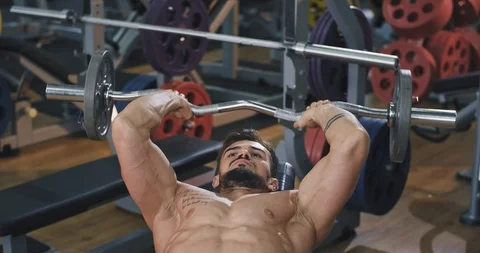 Gym class man bodybuilding doing a hard workout lifting up the weights Stock Footage 114763839