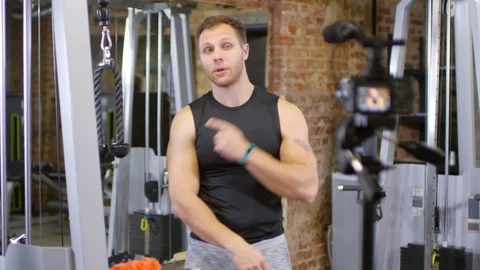 Gym Coach Recording Video Tutorial of Pulley Machine Workout Stock Footage 107602585