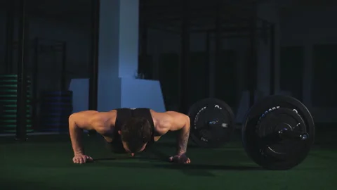Gym man push-up strength pushup exercise with dumbbell in a crossfit workout Stock Footage 91159065