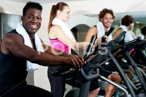 Gym trainer exercising along with his trainees Stock Photos