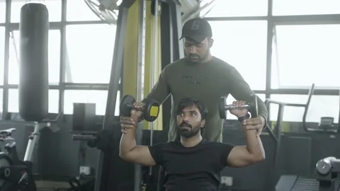 Gym trainer helping athlete to use dumbells during workout - concept of fitness Stock Footage 169916188