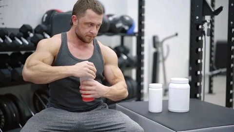 Gym trainer shaking shaker and mixing powder vitamins with water, energy Stock Footage 100461579