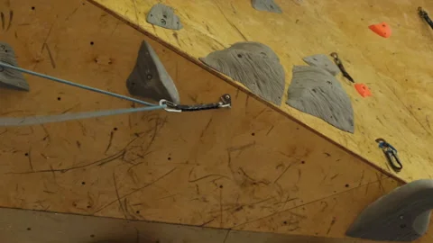 Gym workers remove safety rope from top of climbing wall Stock Footage 276349416