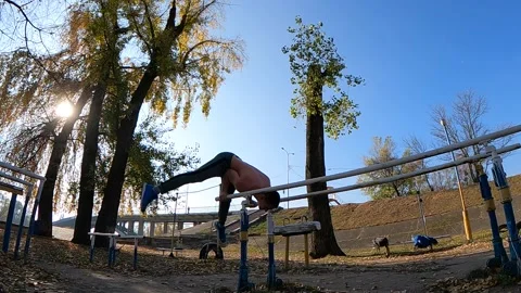 Gymnast does tricks on parallel bars outdoor. Concept of willpower, motivation Video stock 167171971