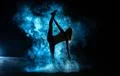 The gymnast doing vertical split in the smoke on the dark background Photo