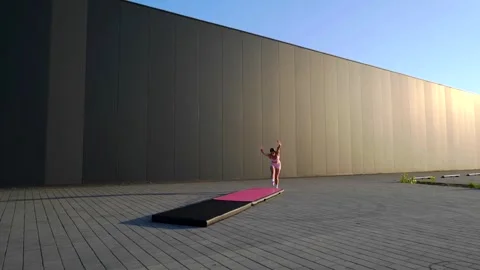 Gymnast Executing Powerful Aerial Flip Against Urban Background. Stock Footage 341682607