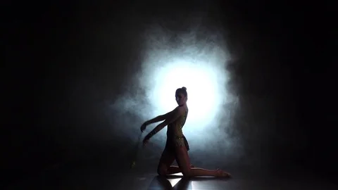 Gymnast with mace doing acrobatic moves. Black background. Slow motion Stock Footage 72683650