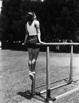 Gymnast on parallel bars outside Foto stock