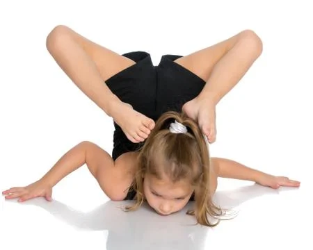 The gymnast perform an acrobatic element on the floor. Stock Photos