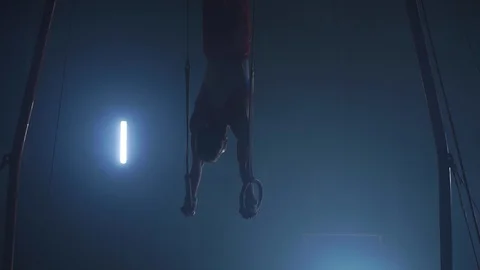 Gymnast performing gymnastic cross exercise on gymnastic rings. Shot in slow Stock Footage 101487490