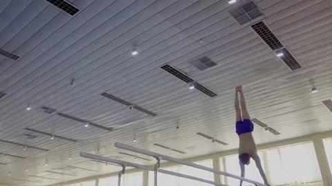 Gymnast performs exercises on parallel bars HD gymnastics video. Athlete skills Stock-Footage 73124587