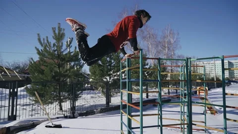 The gymnast performs tricks jumping backwards with a flip in the snow Stock Footage 235876528