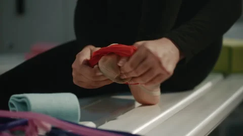 Gymnast Preparing Foot for Training with Elastic Band in Locker Room Stock Footage 339004746