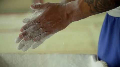 Gymnastics - Athlete clapping hands chalk powder close up Stock Footage 117186468