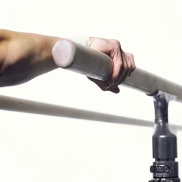Gymnast's hand grasping parallel bar, close-up Stock Photos
