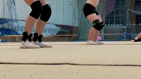 Gymnasts warm up before the tournament, squat. Weights are worn on the legs. Stock Footage 254077813