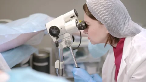 Gynecologist examines a patient using microscope in a gynecological chair Vídeo Stock 329600080