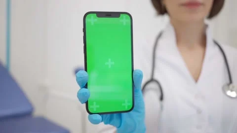 Gynecologist shows an iPhone 12 with a chromakey. The doctor in the Stock Footage
