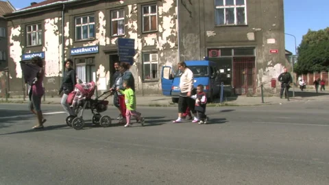 Gypsy family ghetto people friends cross street walking road, devastated houses Stock Footage