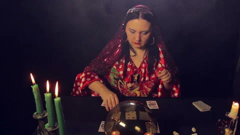 Gypsy fortune-teller at the table by candlelight wonders on the cards 库存影片 101795361