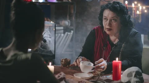 Gypsy witch predicting future of client reading holding coffee cup Stock Footage 136887692