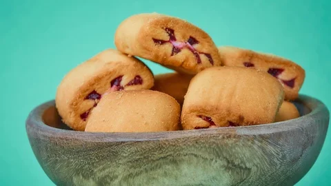 Gyration delicious shortbread with red berry filling in wooden bowl on a gree Stock Footage 117101655