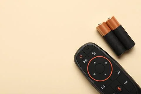Gyroscopic remote controller with batteries on beige background 库存照片