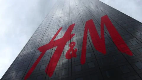 H M logo on a skyscraper facade reflecting clouds. Editorial 3D rendering Stock Illustration