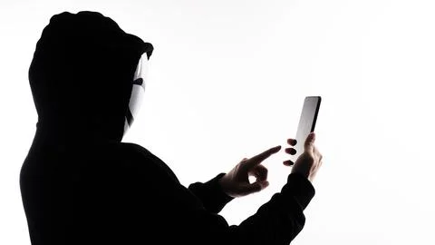 Hacker Anonymous and face mask with smartphone in hand. Stockfoto's