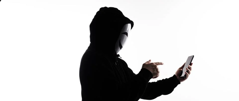 Hacker Anonymous and face mask with smartphone in hand. Stockfoto's