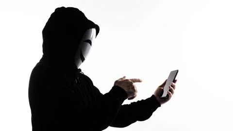 Hacker Anonymous and face mask with smartphone in hand. Stock Photos