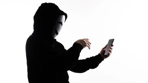 Hacker Anonymous and face mask with smartphone in hand. Stock Photos