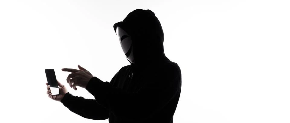 Hacker Anonymous and face mask with smartphone in hand. Stockfoto's