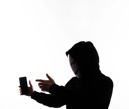 Hacker Anonymous and face mask with smartphone in hand. Stockfoto's