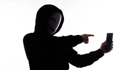 Hacker Anonymous and face mask with smartphone in hand. Stockfoto's