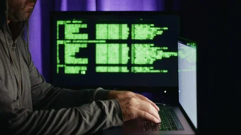 Hacker approaches computer and enters code to conduct cyber attack and hack.. 写真素材